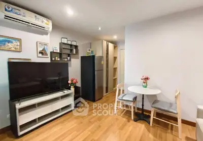 Modern living room with sleek TV, air conditioning, and stylish decor in a cozy apartment.