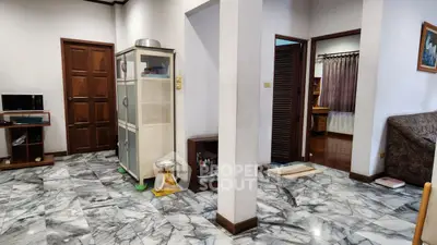 Spacious interior with marble flooring and wooden accents, featuring a cozy living area and modern kitchen.