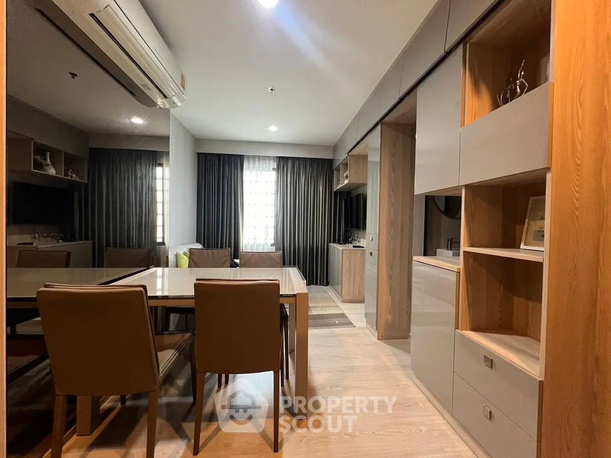 Modern dining area with sleek furniture and built-in storage in a stylish apartment.