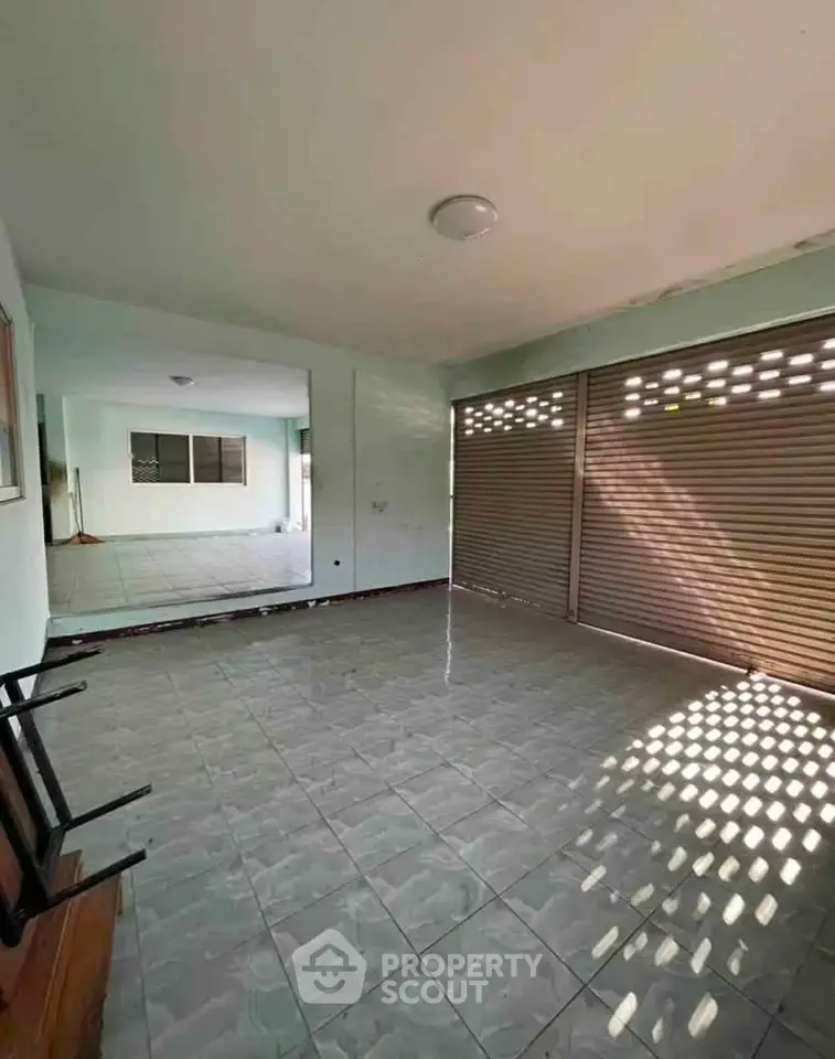 Spacious tiled room with large windows and ample natural light, perfect for versatile use.