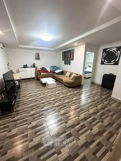 Spacious living room with modern decor and stylish tiled flooring, perfect for relaxation and entertainment.
