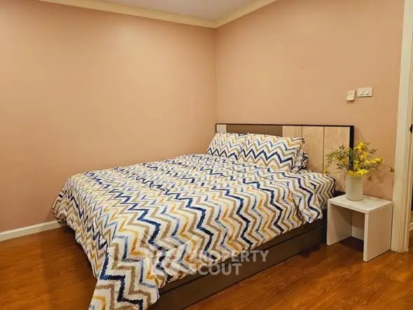 Cozy bedroom with stylish chevron bedding and wooden flooring, perfect for relaxation.