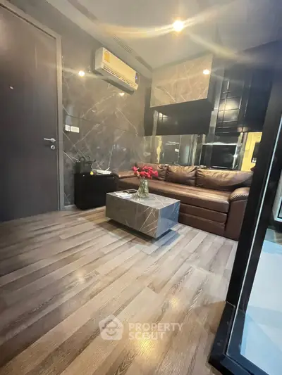 Modern living room with sleek design and marble accents, featuring a cozy leather sofa and stylish coffee table.