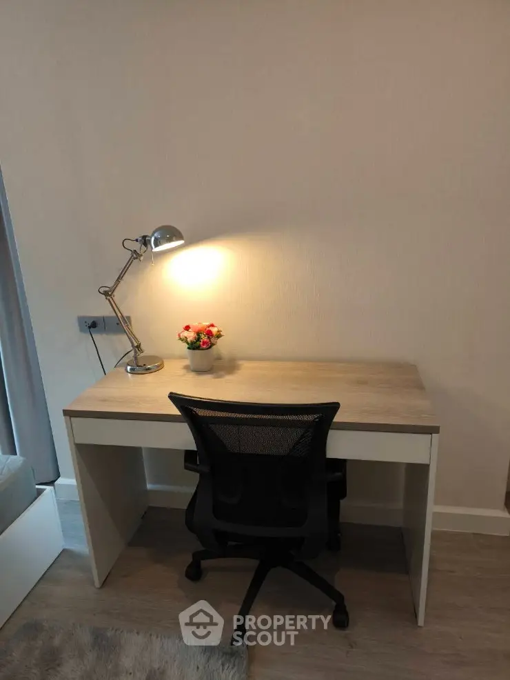 Modern study area with sleek desk, ergonomic chair, and stylish lamp in cozy apartment.