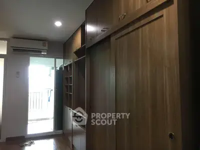 Spacious bedroom with built-in wooden wardrobe and balcony access, perfect for modern living.