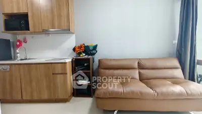 Modern compact living room with kitchenette and stylish brown sofa