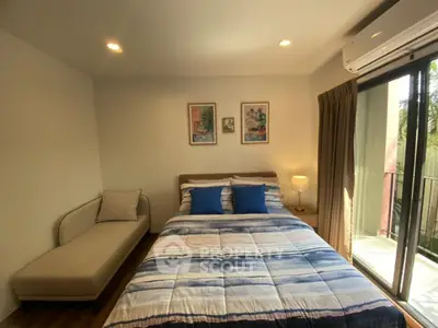 Cozy bedroom with modern decor and balcony access in a stylish apartment