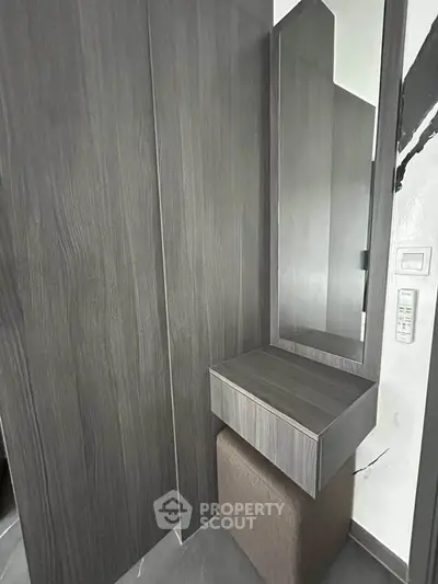 Modern minimalist vanity area with sleek wood paneling and mirror