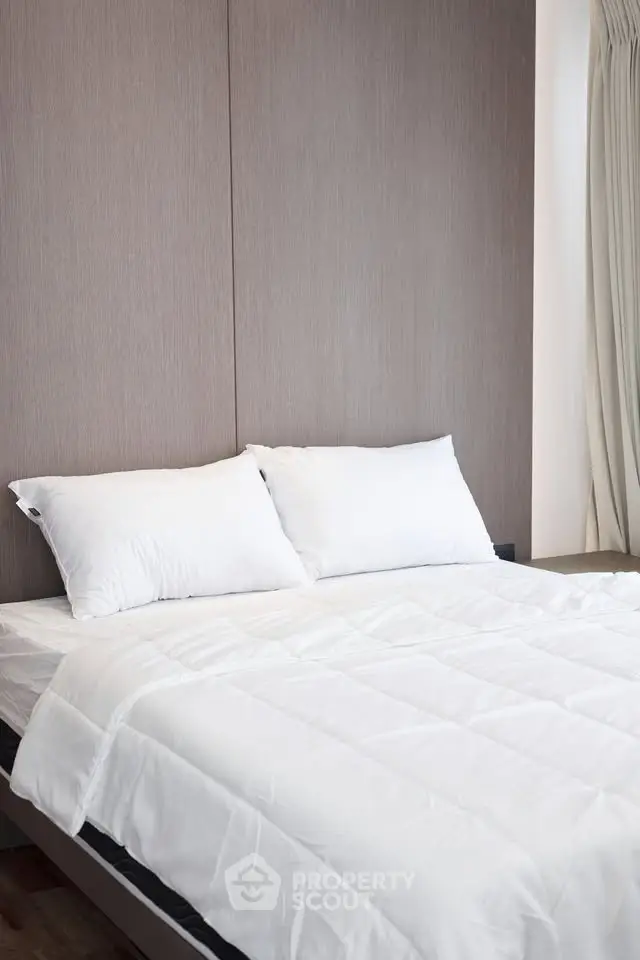 Modern bedroom with elegant design and cozy bedding in a stylish apartment.