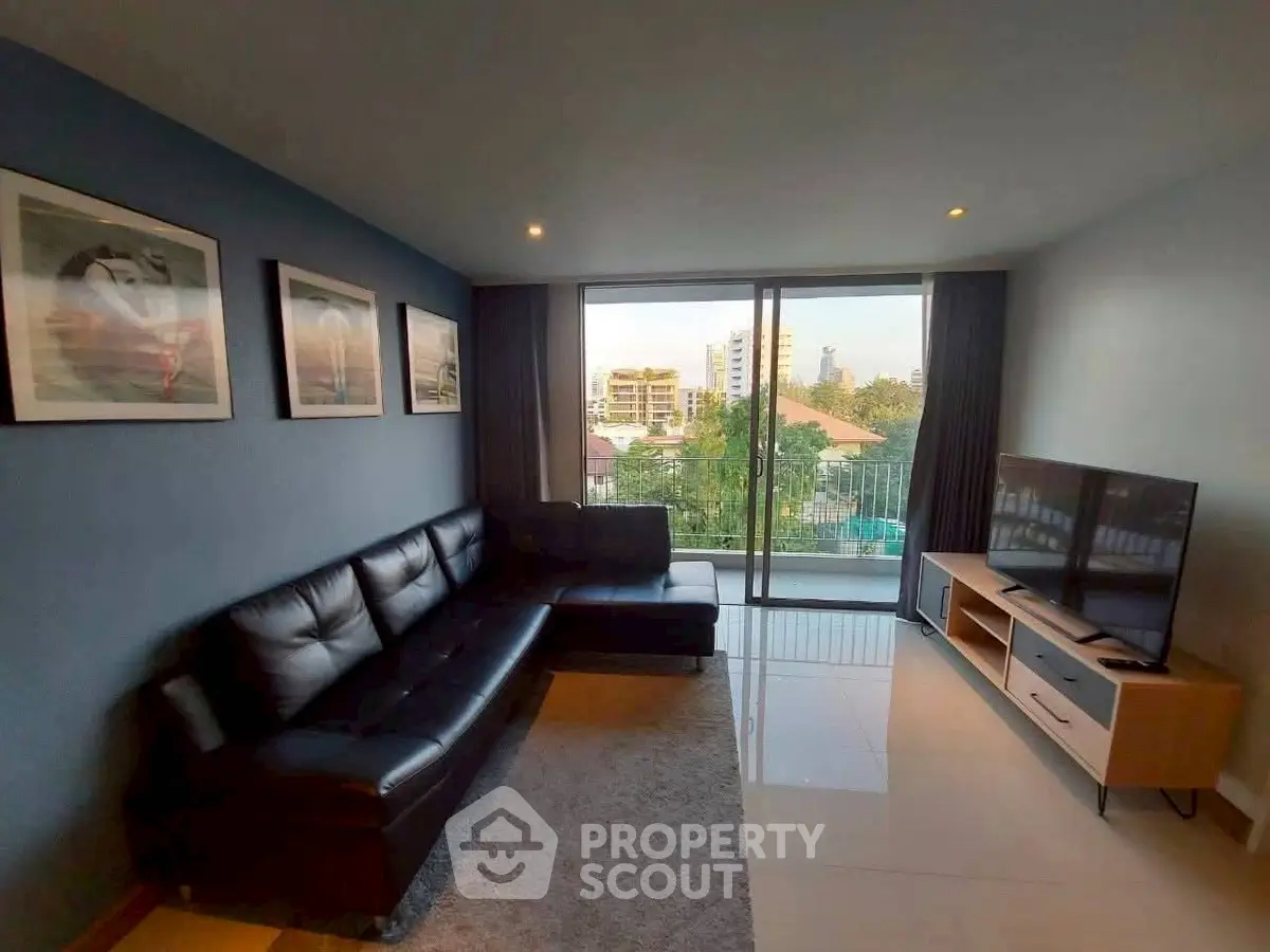 Spacious living room with modern decor and city view balcony, perfect for urban living.
