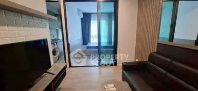 Modern living room with sleek furniture and view into a cozy bedroom