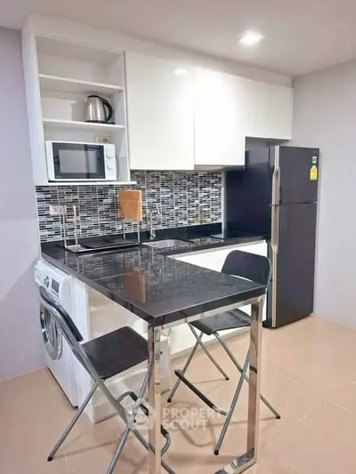 Modern kitchen with sleek appliances and stylish backsplash