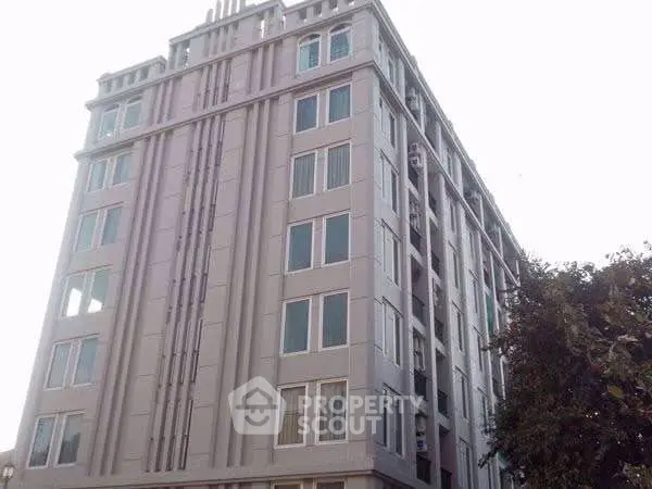 Modern multi-story building with sleek facade and large windows, ideal for urban living.