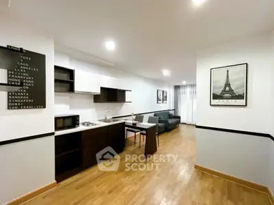 Modern open-layout kitchen and living room with stylish decor and hardwood floors.