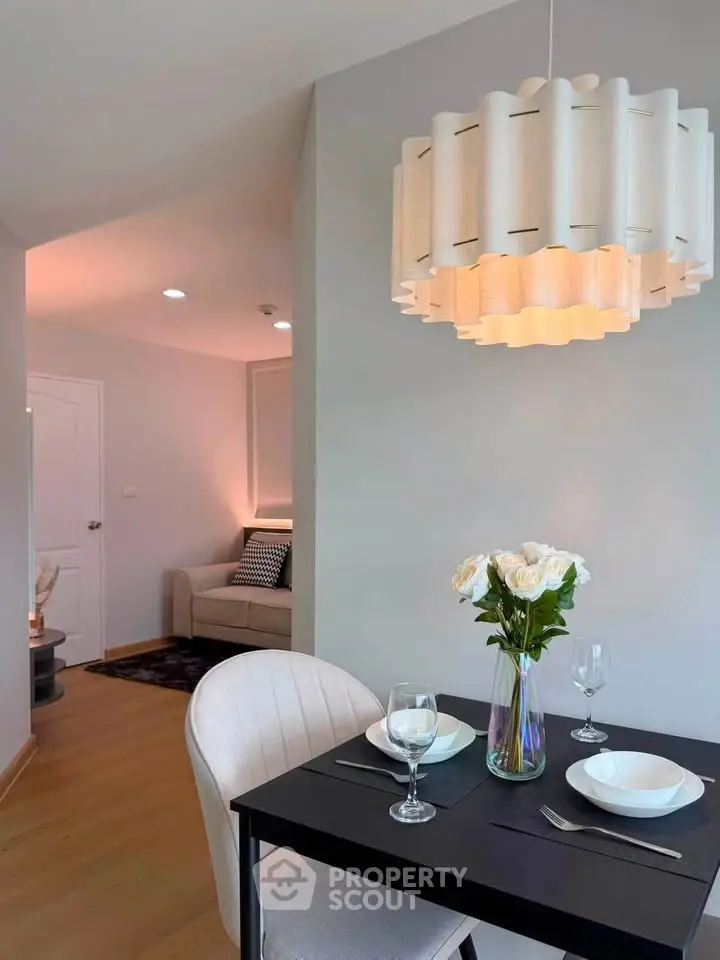 Modern dining area with elegant lighting and cozy seating in a stylish apartment.