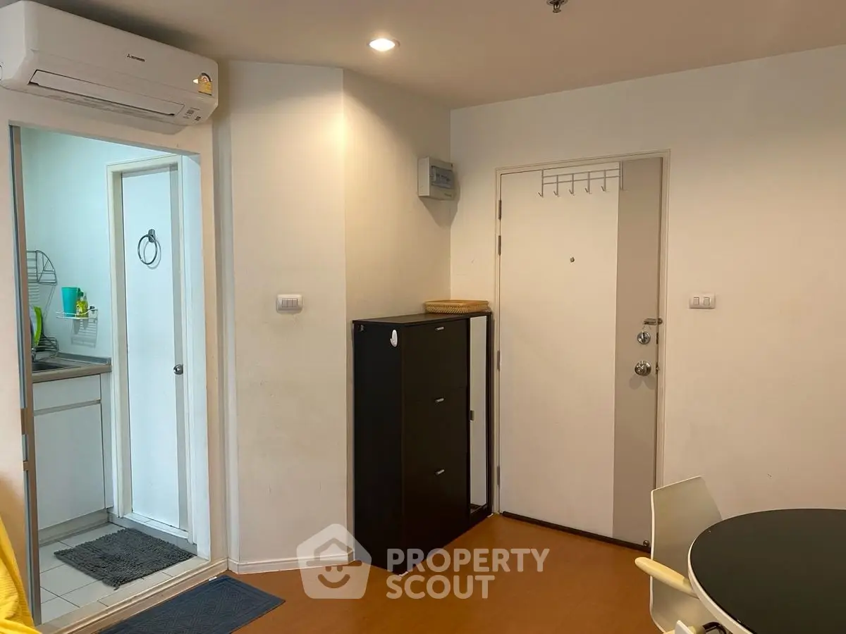 Modern apartment entrance with sleek storage and kitchen view