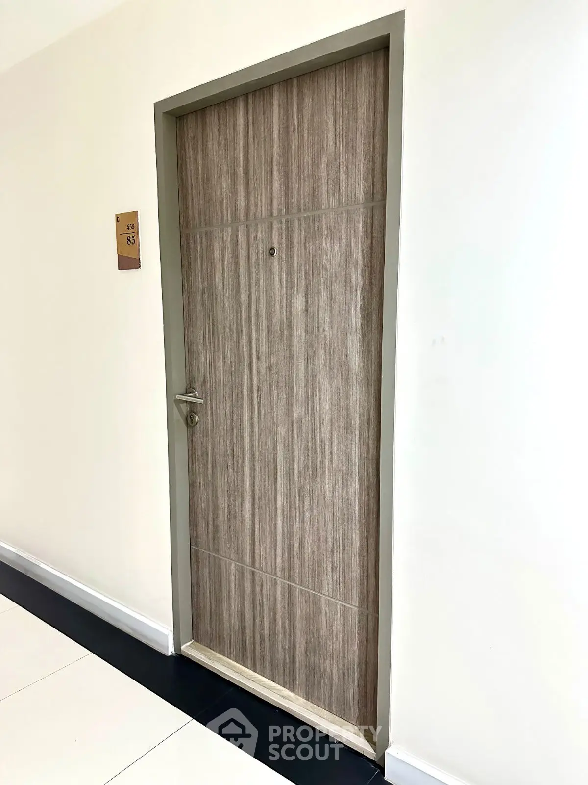Modern apartment entrance with sleek wooden door and minimalist design.