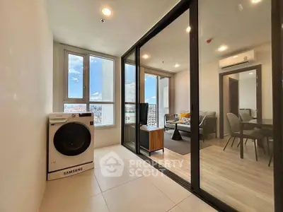 Modern apartment with glass partition, cozy living area, and Samsung washing machine.