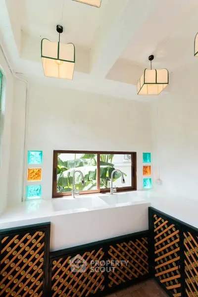 Charming kitchen with dual sinks and colorful glass accents, perfect for modern living.