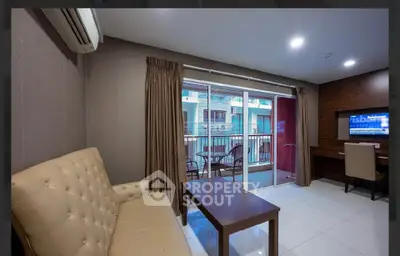 Modern living room with balcony view, featuring elegant furniture and ample natural light.