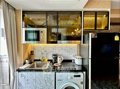 Modern kitchen with marble countertops, built-in microwave, and washing machine