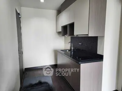 Modern compact kitchen with sleek cabinetry and black countertop
