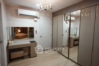 Elegant bedroom with mirrored wardrobe and chandelier lighting