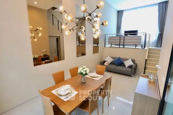 Modern duplex living room with stylish chandelier and elegant dining area.