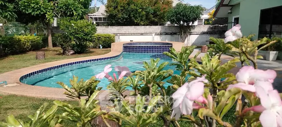 Charming backyard pool with lush garden and vibrant flowers, perfect for relaxation and outdoor enjoyment.