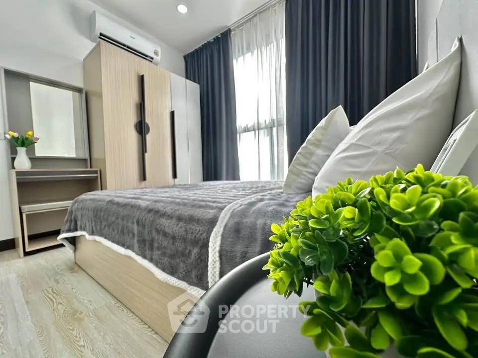 Modern bedroom with stylish decor and natural light, featuring a cozy bed and elegant furnishings.