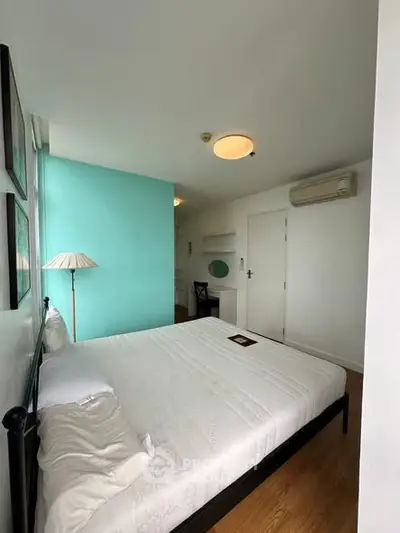 Bright bedroom with teal accent wall and modern furnishings