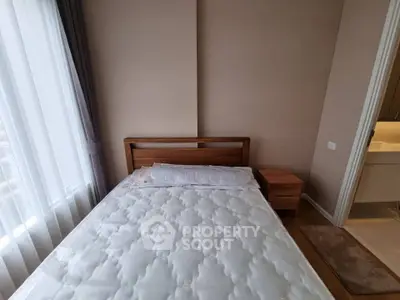 Cozy bedroom with natural light and modern wooden furniture, perfect for relaxation and comfort.