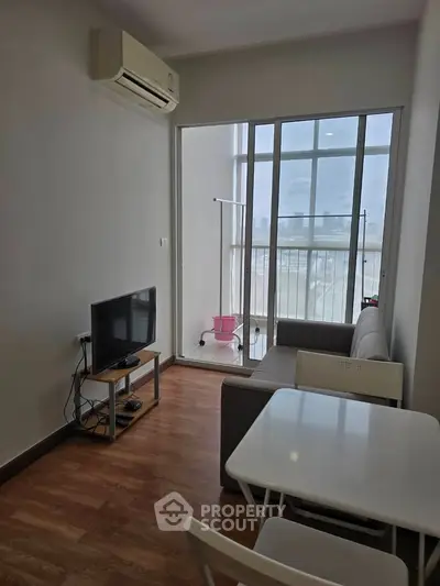 Modern living room with balcony view, featuring sleek furniture and air conditioning.