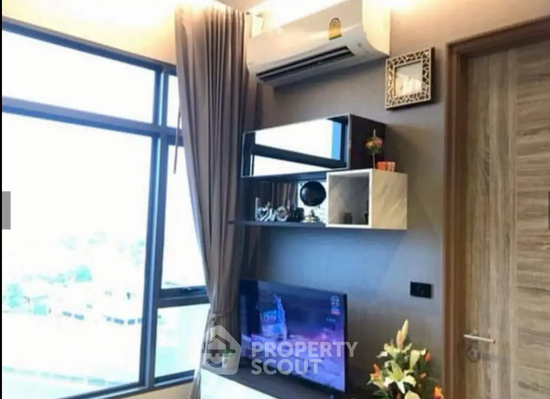 Modern living room with large window, air conditioning, and stylish decor