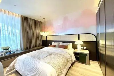 Luxurious bedroom with elegant decor and large window, featuring a cozy bed and stylish lighting.