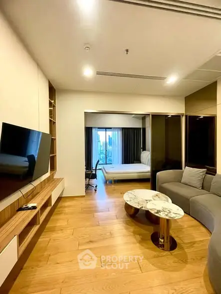 Modern living room with wooden flooring and stylish furniture in open layout apartment.