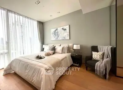 Luxurious bedroom with elegant decor and large windows offering city views.
