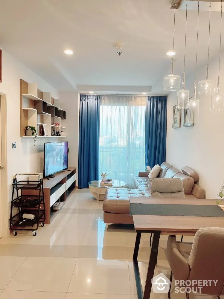 Modern living room with stylish decor and large windows offering natural light.