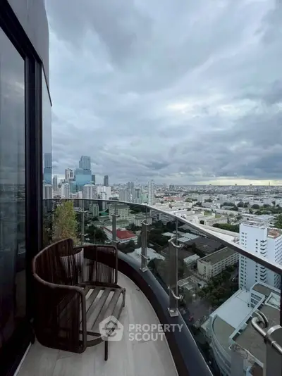Stunning cityscape view from a modern high-rise balcony with sleek glass railing.