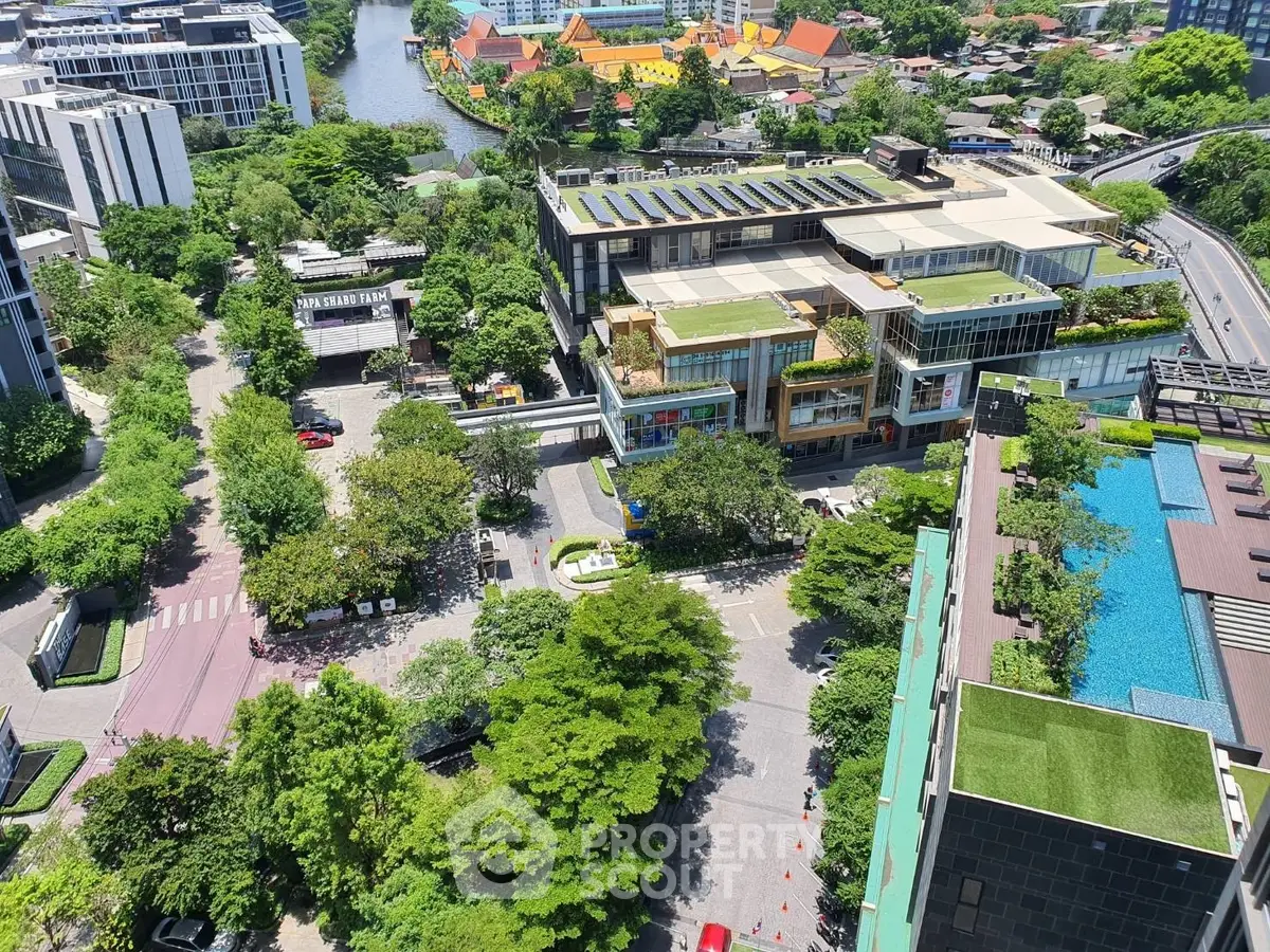Stunning aerial view of modern building with rooftop garden and pool in vibrant urban setting.