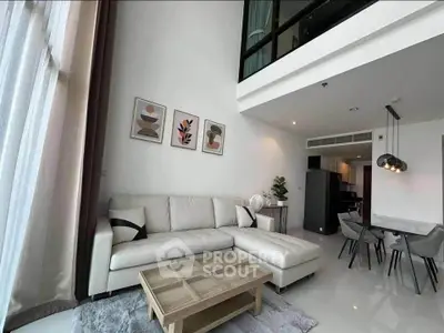 Modern living room with high ceilings and stylish decor in a luxury apartment.