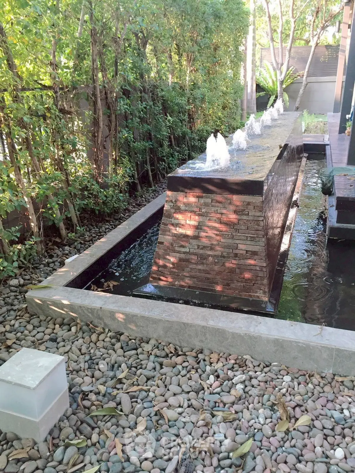 Elegant garden water feature with modern stone fountain and lush greenery