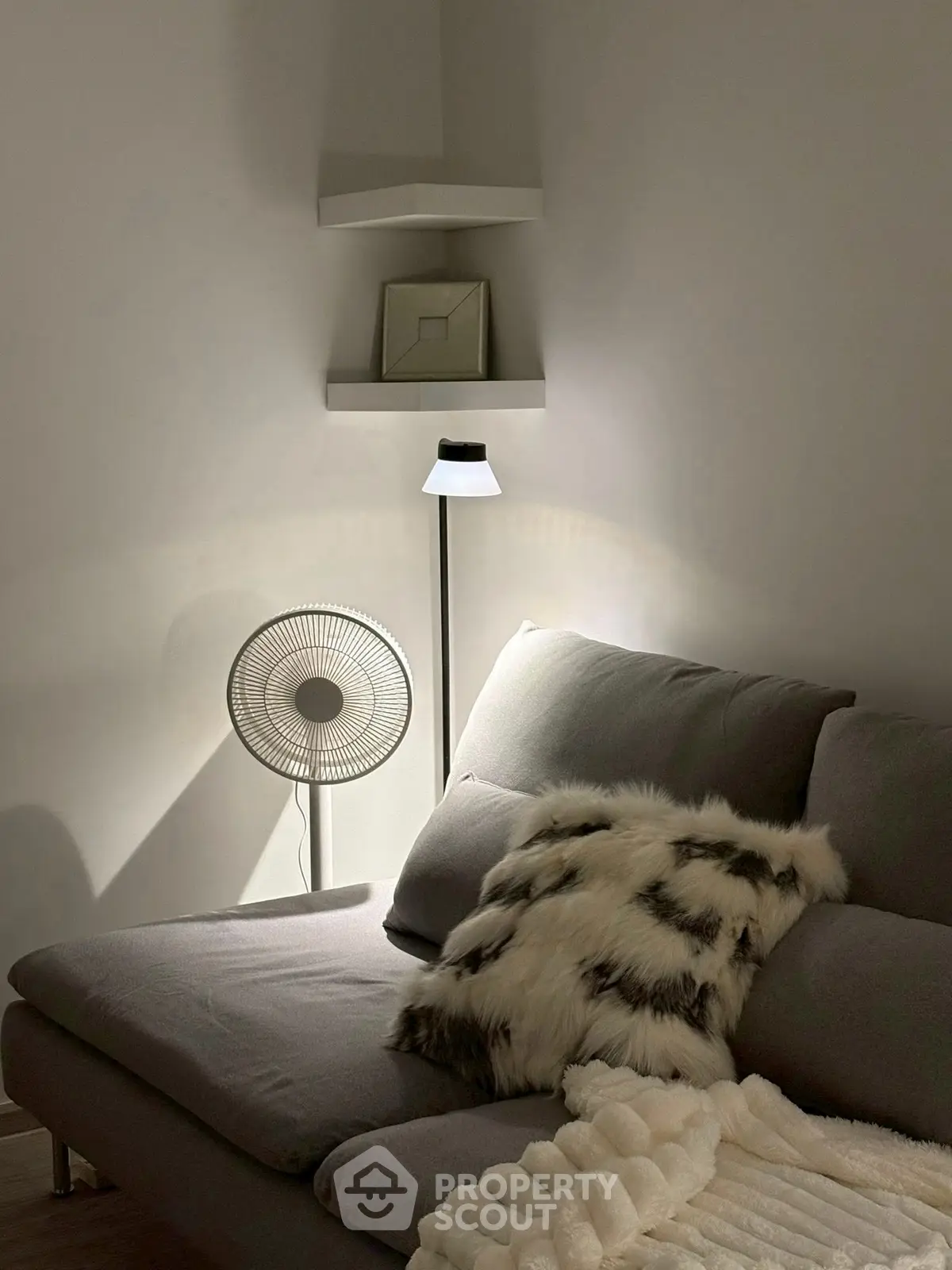 Cozy living room with modern sofa, stylish lamp, and decorative pillows.