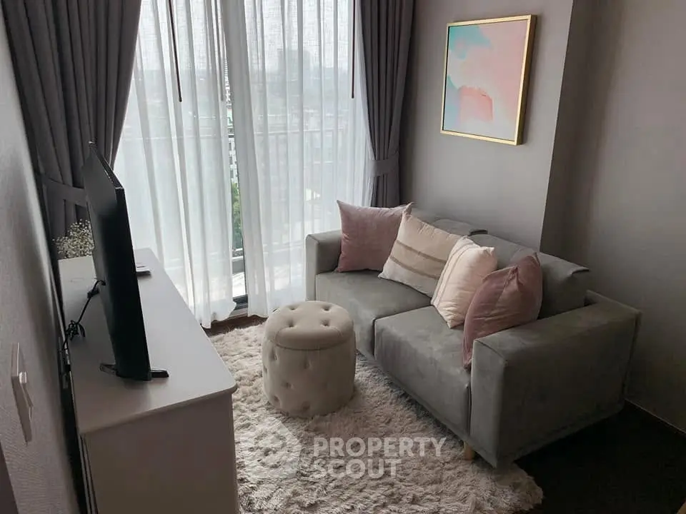 Cozy living room with modern decor, plush sofa, and large window with city view.