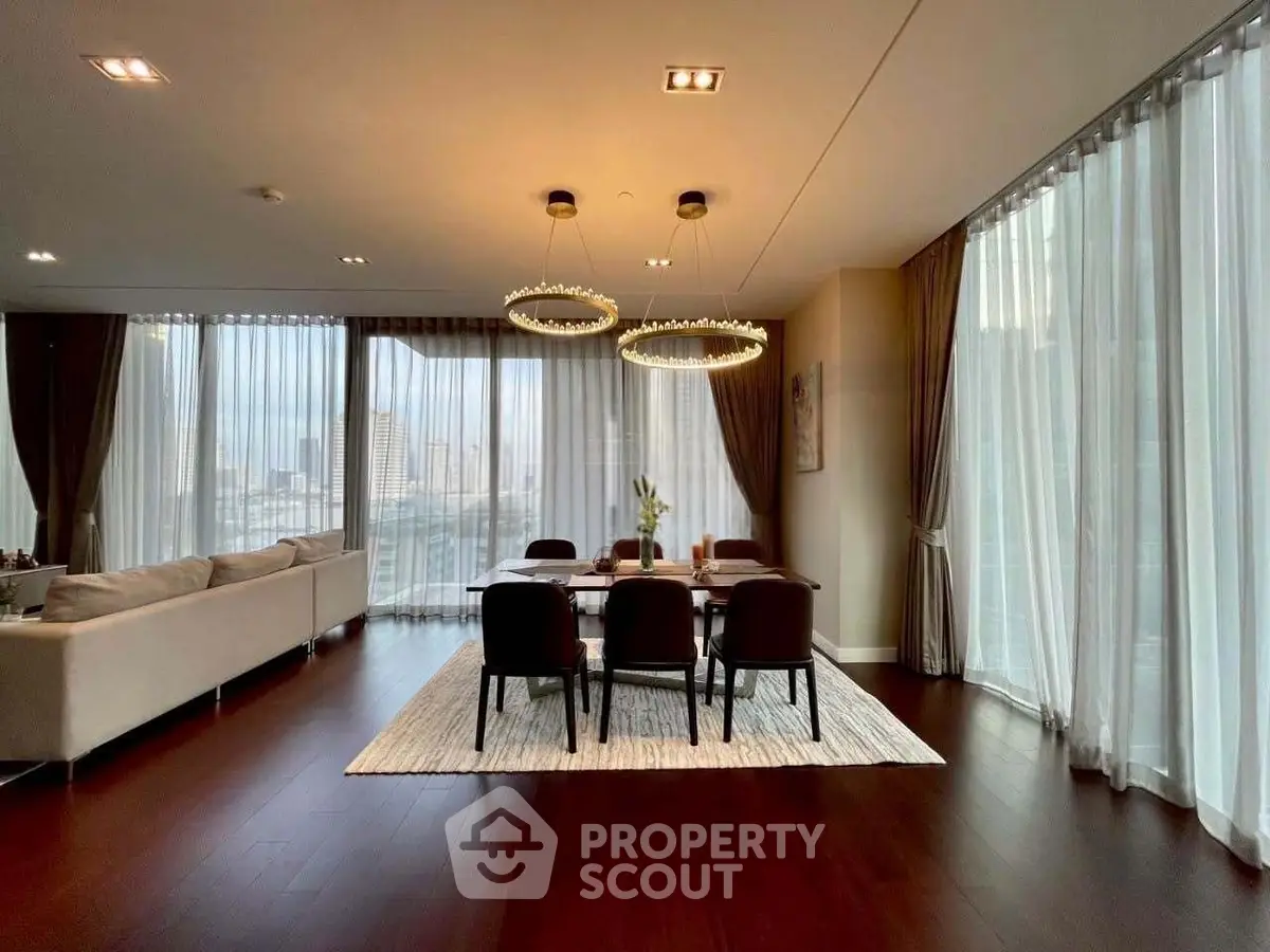 Luxurious open-plan living and dining area with floor-to-ceiling windows and elegant lighting.