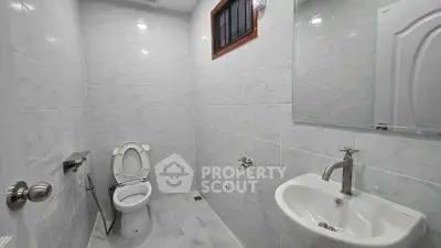 Modern bathroom with sleek fixtures and white tiled walls.