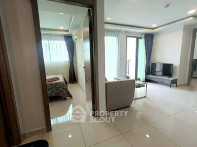Modern apartment interior with open living room and bedroom, featuring sleek design and natural light.