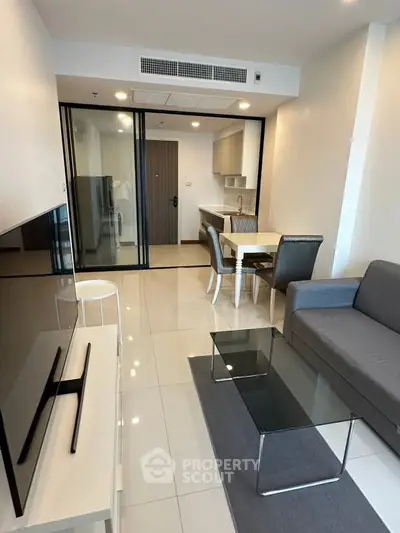 Modern living room with sleek furniture and open kitchen layout in a stylish apartment.