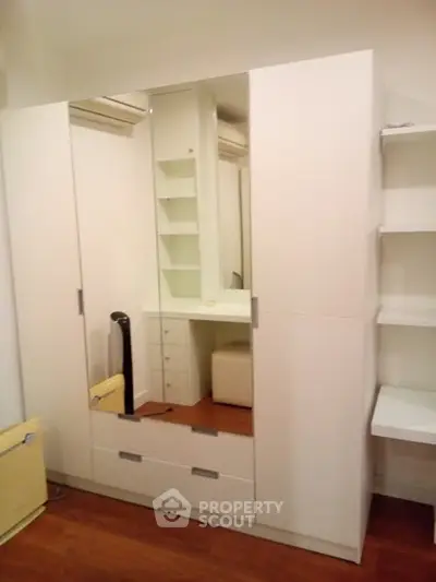 Spacious white wardrobe with mirror in modern bedroom interior
