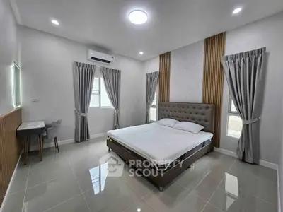 Modern bedroom with stylish decor and natural light, featuring a comfortable bed and sleek tiled flooring.